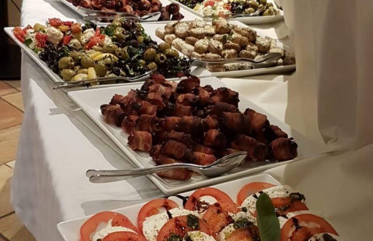 kleines Antipastibuffet zur geschlossenen Gesellschaft Ein Buffet mit verschiedenen Platten, darunter Fleisch, Gemüse und Salate.